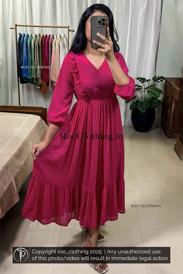 Woman wearing fuchsia pink chiffon midi dress with v-neckline, balloon sleeves, empire waist, and tiered hem – Roo Clothing
